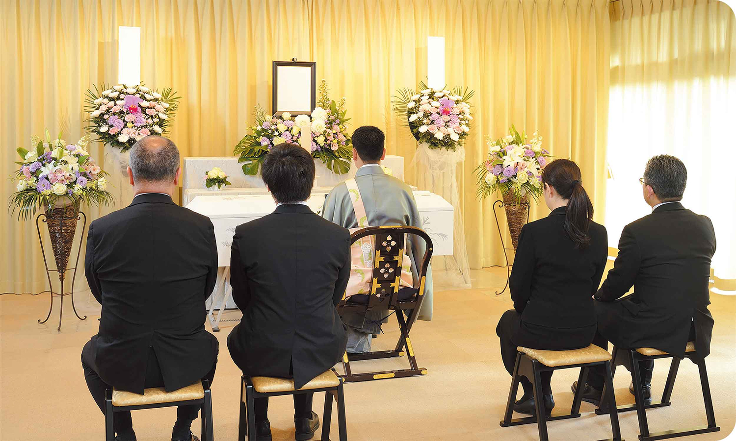 僧侶とご遺族が祭壇に向かい葬儀を執り行っている