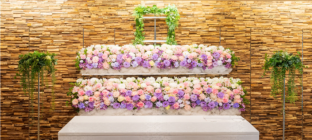 紫色やピンク色などのカラフルな花を基調とする綺麗な祭壇